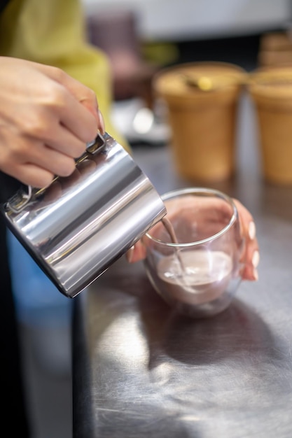 Cacao. Cerrar imagen de manos de una mujer vertiendo cacao en el vaso