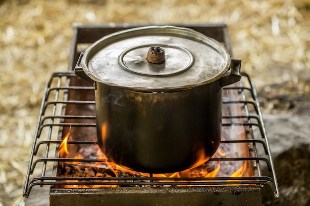 Cacerola al fuego, el concepto de camping y recreación.