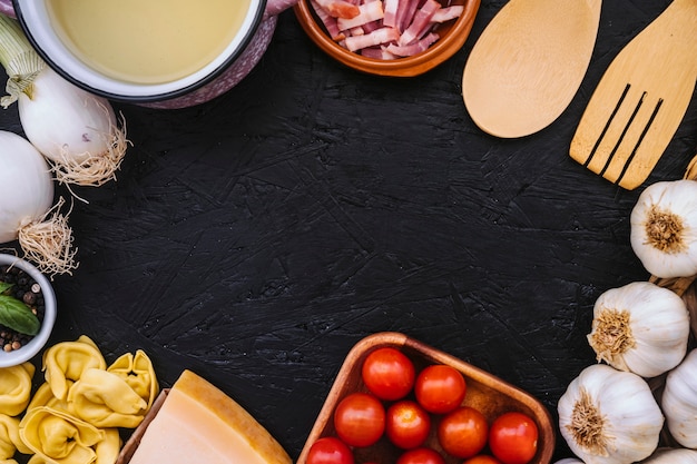 Cacerola y utensilios cerca de los ingredientes de la pasta