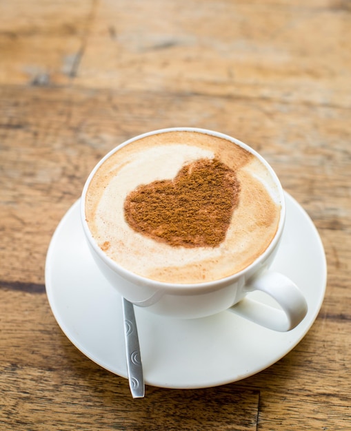 Foto gratuita café amoroso taza de capuchino fresco con signo de corazón