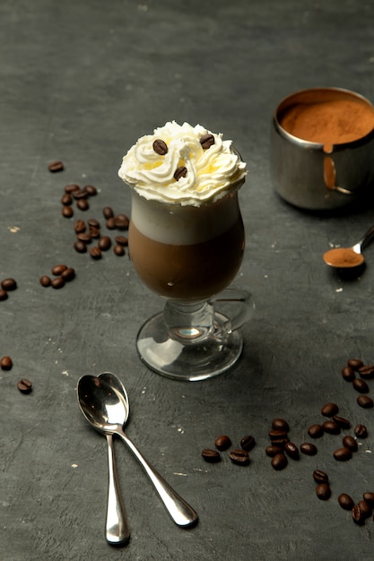 Café aromático en una taza de vidrio con crema batida