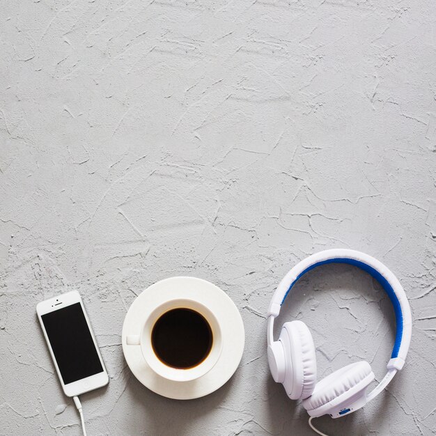 Café, auriculares y teléfono