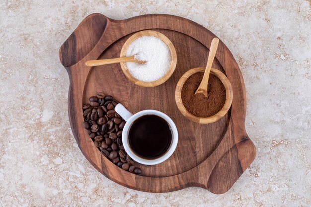 Café y azúcar en una pequeña bandeja de madera.