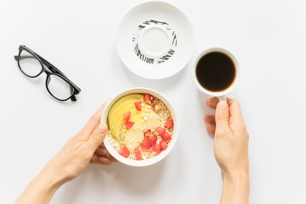 Café y bol con frutas y cereales.