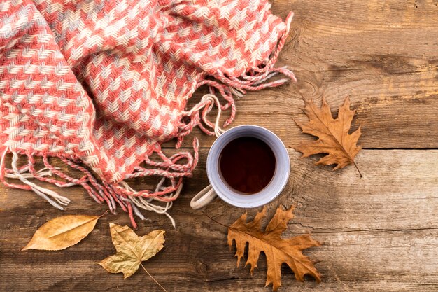 Café y bufanda sobre fondo de madera