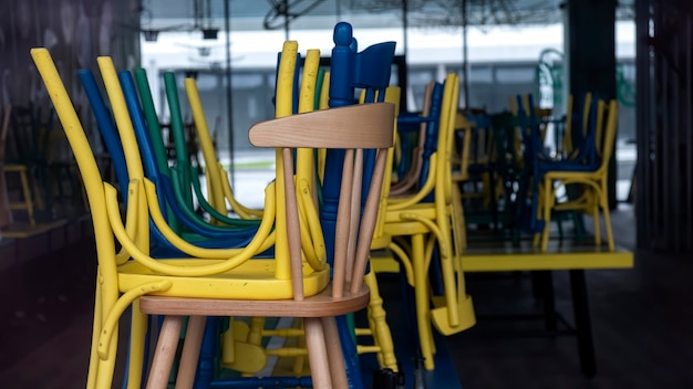 Café cerrado con sillas multicolores levantadas visibles a través de la fachada de cristal en Bucarest, Rumania