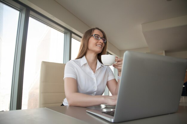 Café de consumición de la empresaria en el escritorio de oficina