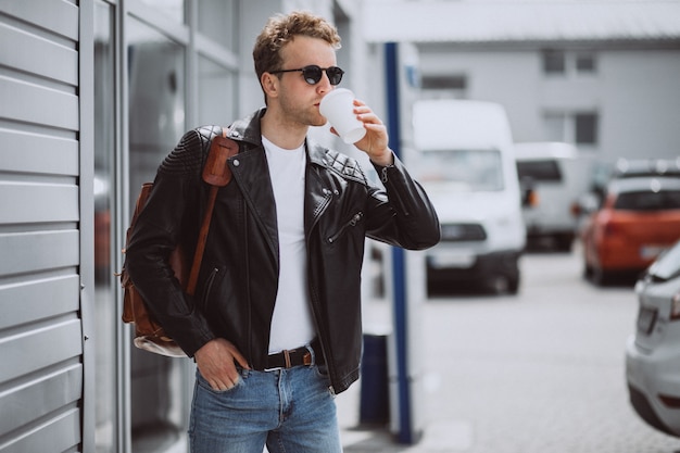 Café de consumición del hombre hermoso joven en la calle