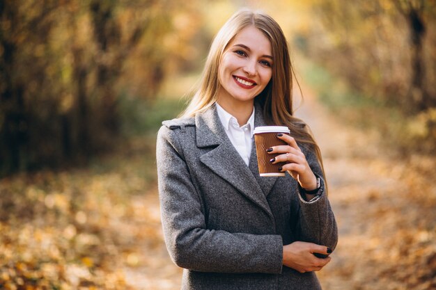 Café de consumición joven de la mujer de negocios al aire libre