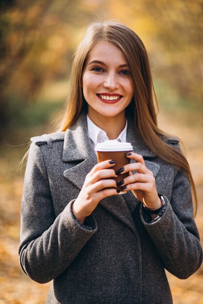 Café de consumición joven de la mujer de negocios al aire libre