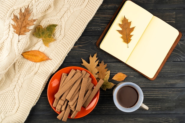 Café y cuaderno sobre fondo de madera