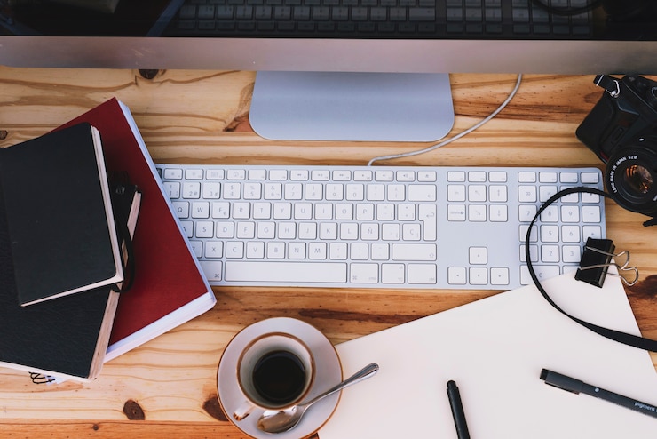 Foto gratuito café y cuadernos cerca de la computadora y la cámara