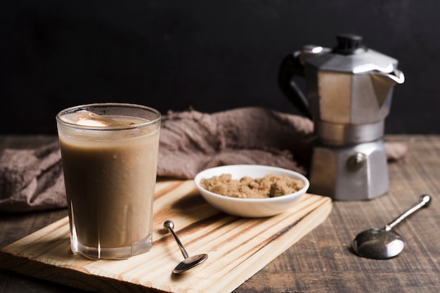 Café con cubitos de hielo en vaso y molinillo