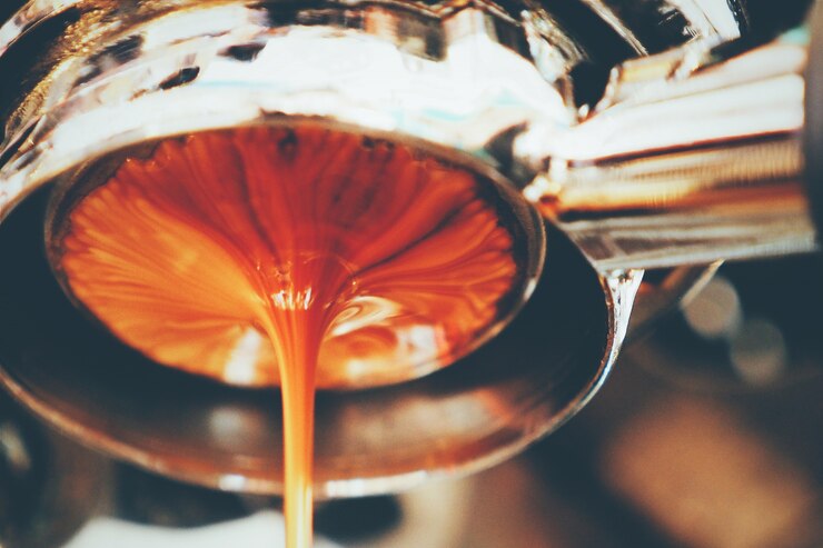 Café espeso cayendo de una máquina