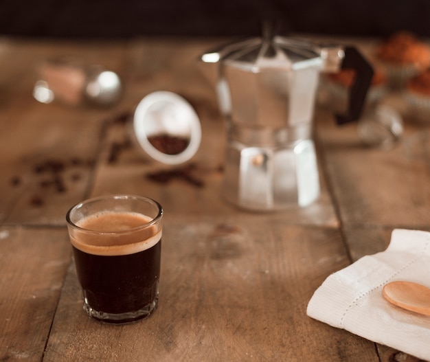 Café espresso en vaso sobre mesa de madera.