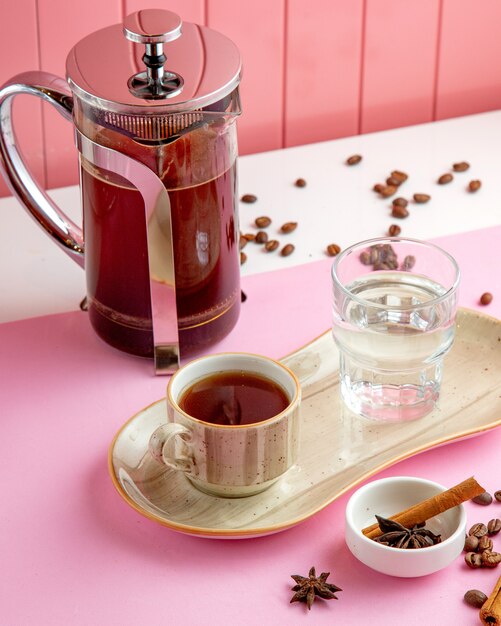 Café en frech prensa vaso de agua y granos de café sobre la mesa