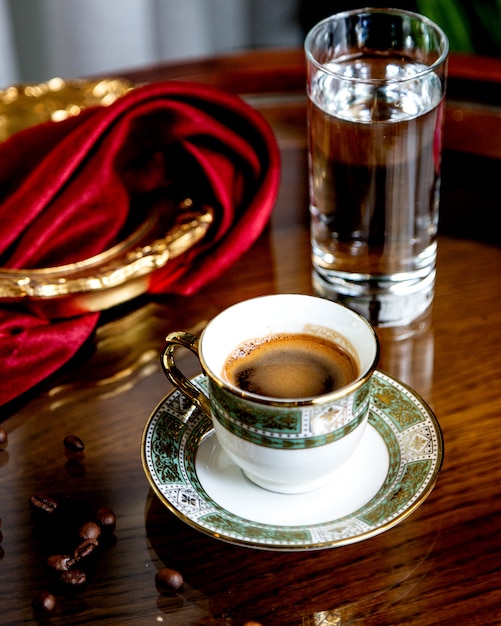 Café fuerte con vaso de agua.