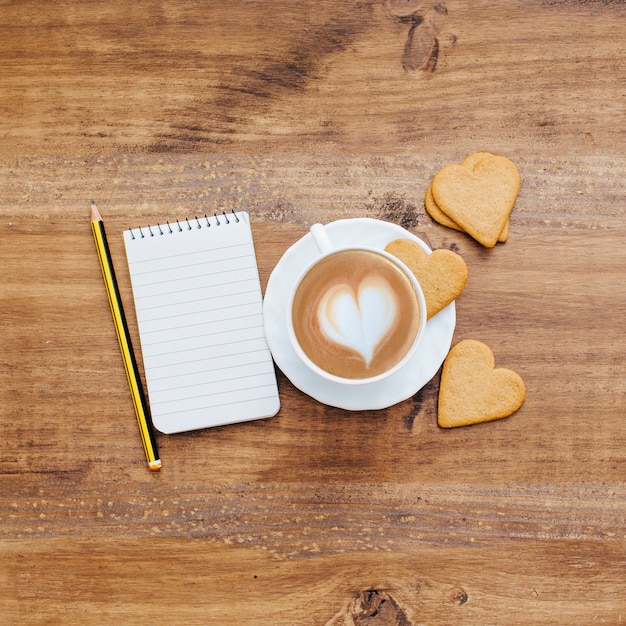 Café con galletas de corazón y cuaderno