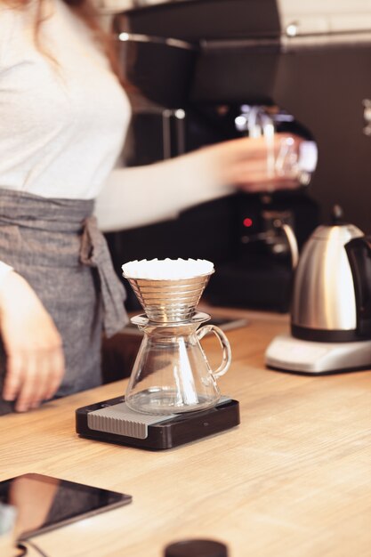 Café de goteo a mano, Barista vertiendo agua sobre café molido con filtro