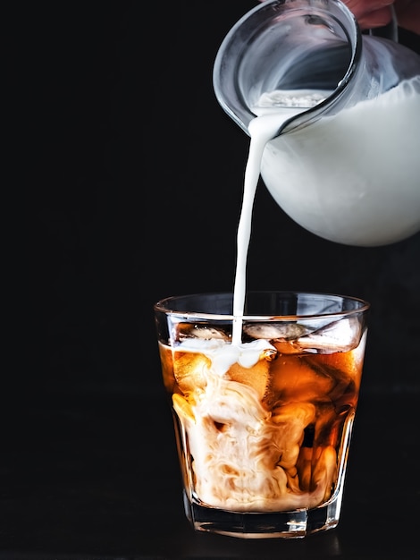 Café helado en un vaso con hielo y jarabe de azúcar