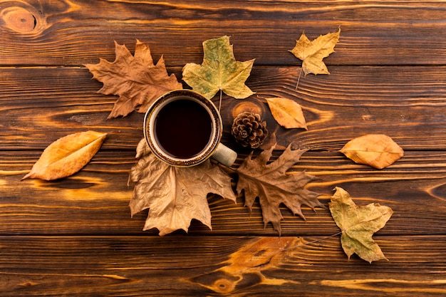 Café y hojas sobre fondo de madera