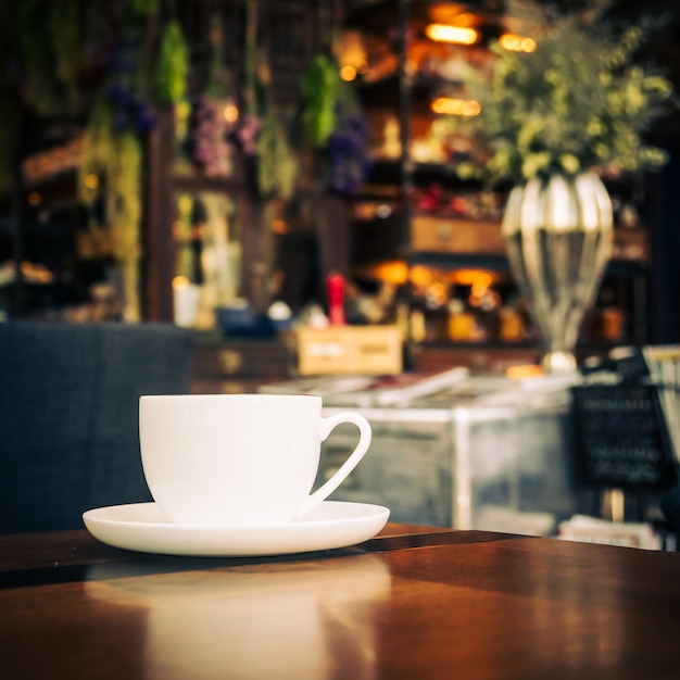 Café con leche caliente en taza blanca en la mesa