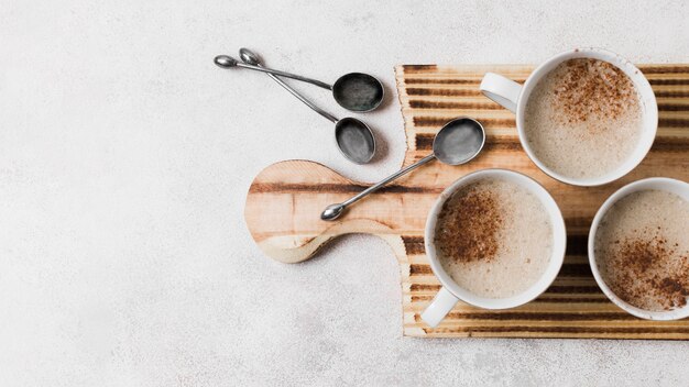 Café con leche sobre tabla de madera con cucharas