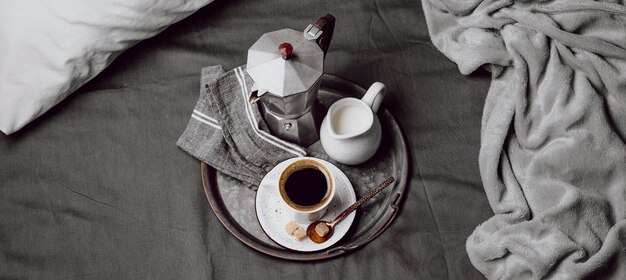 Café de la mañana en la cama con leche y hervidor