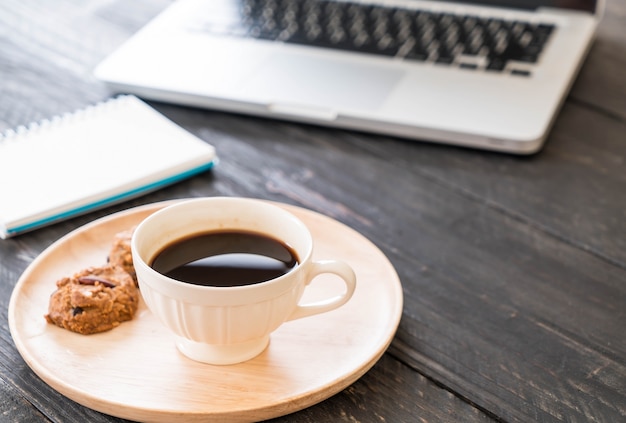 café negro y galletas con portátil y cuaderno