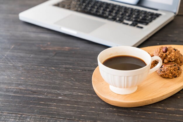 café negro y galletas con portátil y cuaderno