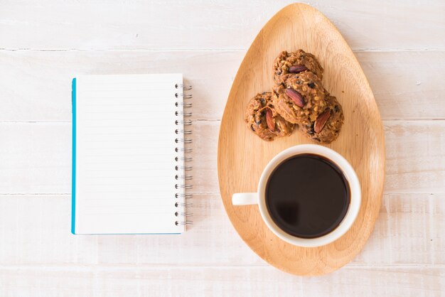 café negro y galletas con portátil y cuaderno