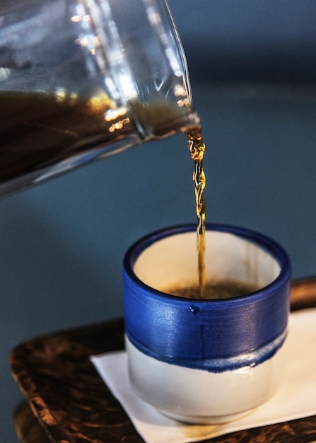 Café negro en una pequeña taza azul