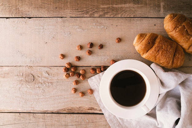 Foto gratuita café plano y croissant de desayuno con espacio de copia.