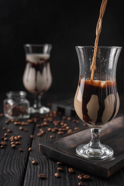 Café vertido en vaso con chocolate y granos de café.