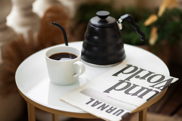 Foto gratuita cafetera de alto ángulo y taza en la mesa