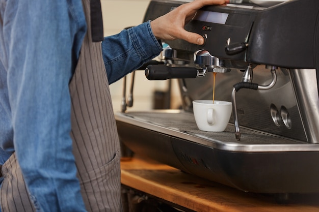 Cafetera profesional. Primer del camarero que hace la bebida del café.