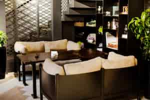 Foto gratuita cafetería con mesas de café, acogedores sofás, plantas y estanterías