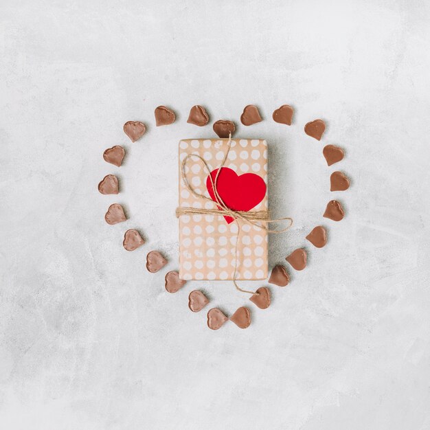Caja actual entre dulces de chocolate dulce en forma de corazón.