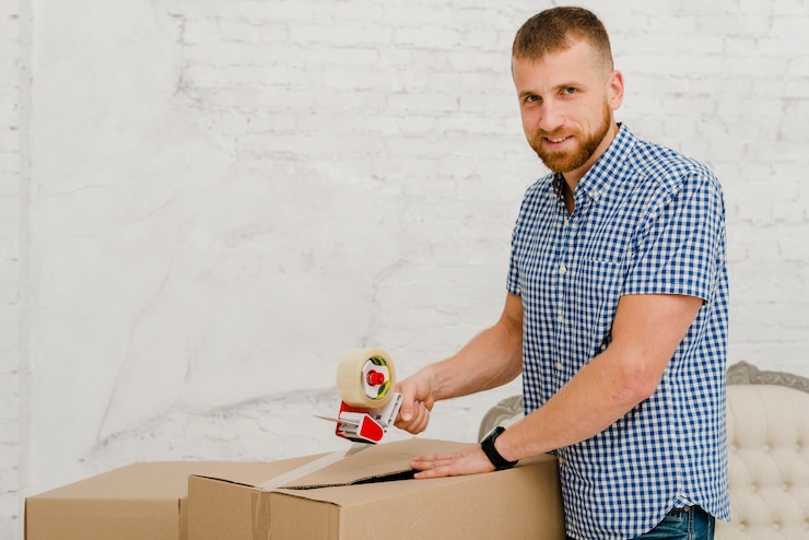 Foto gratuito caja de embalaje de hombre guapo