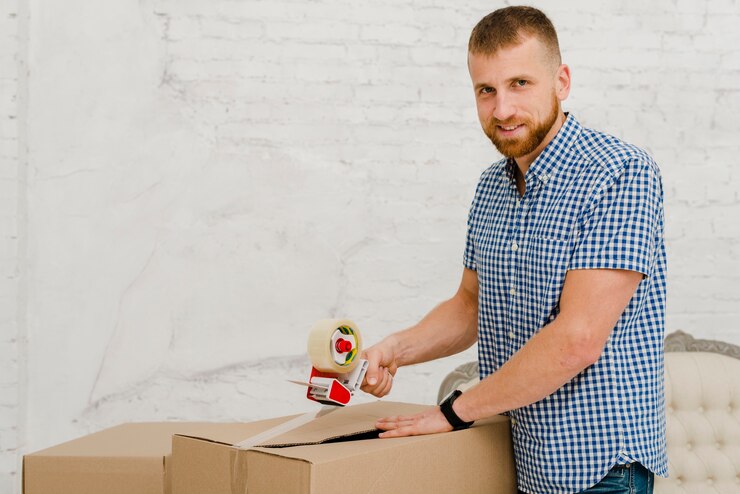 Foto gratuito caja de embalaje de hombre guapo