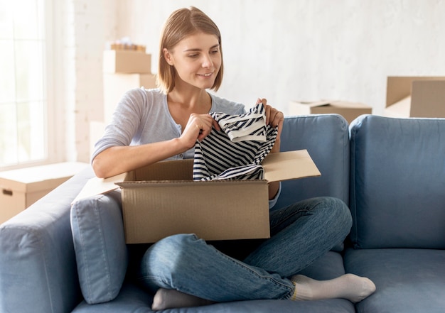 Caja de embalaje de mujer con ropa para mudanza