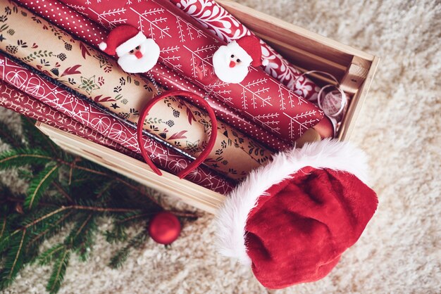 Caja de madera con papel navideño y gorro de santa