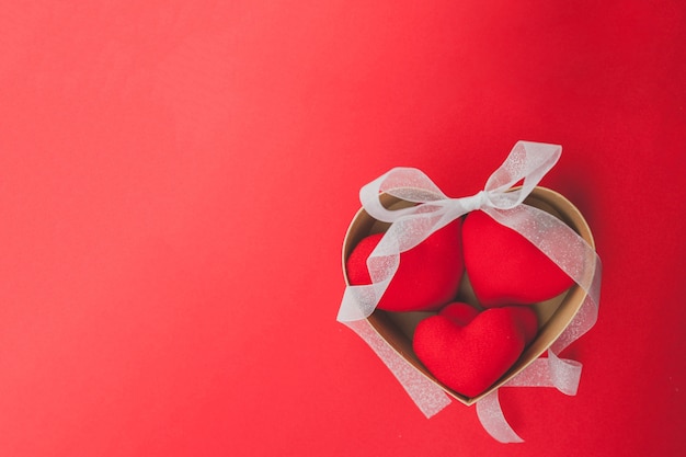 Caja marrón con corazones dentro y un lazo blanco