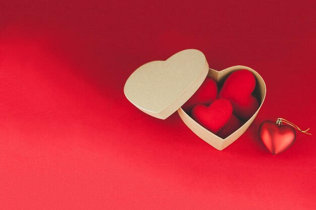 Caja marrón con corazones dentro en una mesa roja