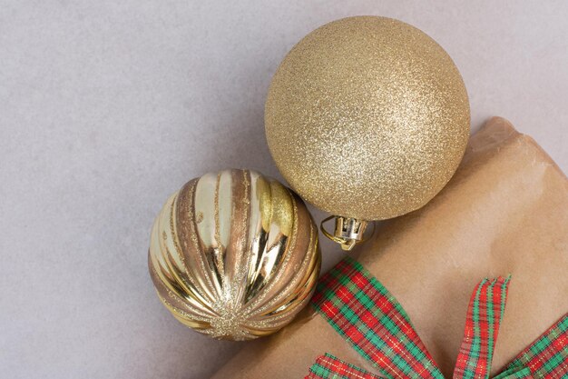 Caja de Navidad con bolas doradas sobre mesa gris