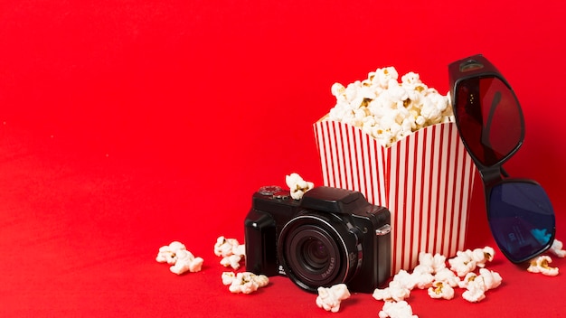 Foto gratuita caja de palomitas de maíz con cámara al lado