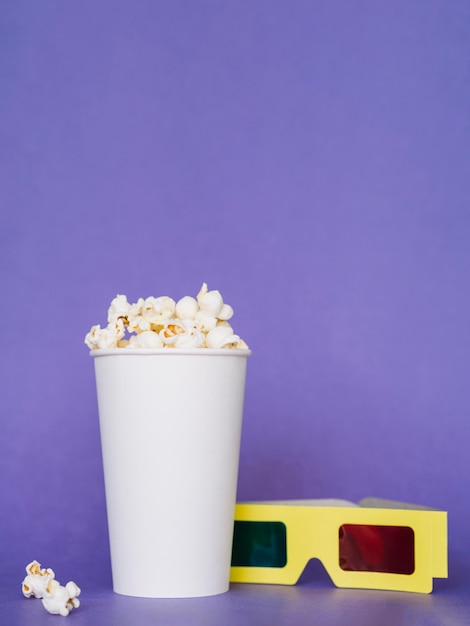 Caja de palomitas de maíz saladas con gafas 3d sobre la mesa