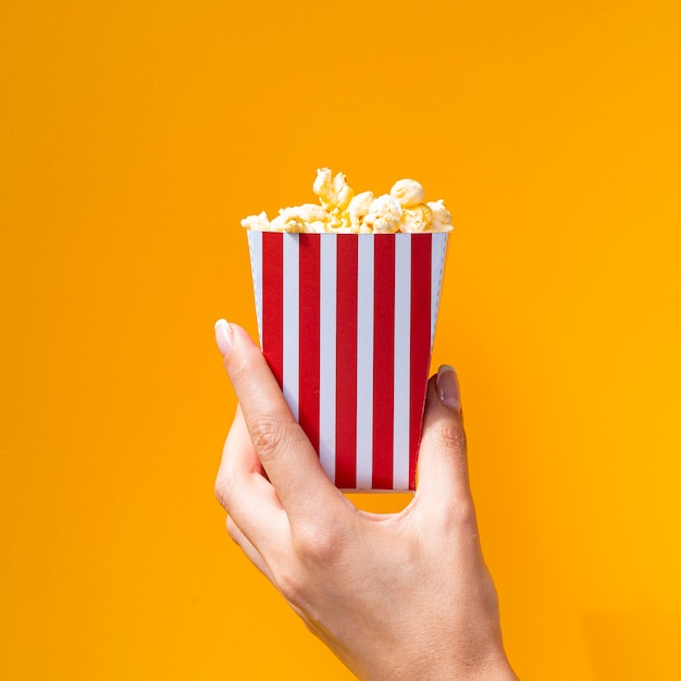 Foto gratuita caja de palomitas de maíz sobre fondo naranja