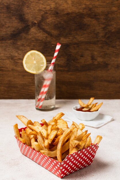 Caja de papas fritas en mesa blanca