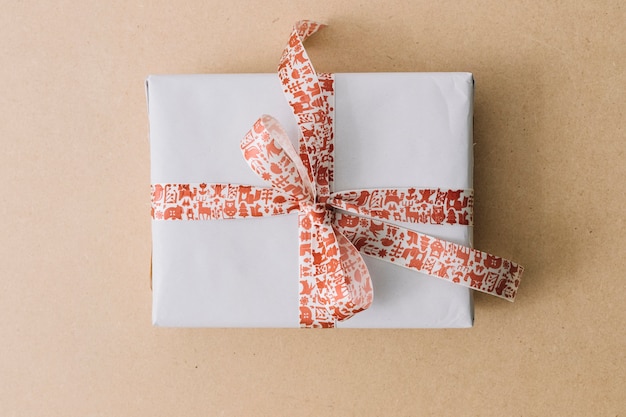 Caja de regalo blanca con cinta en mesa marrón